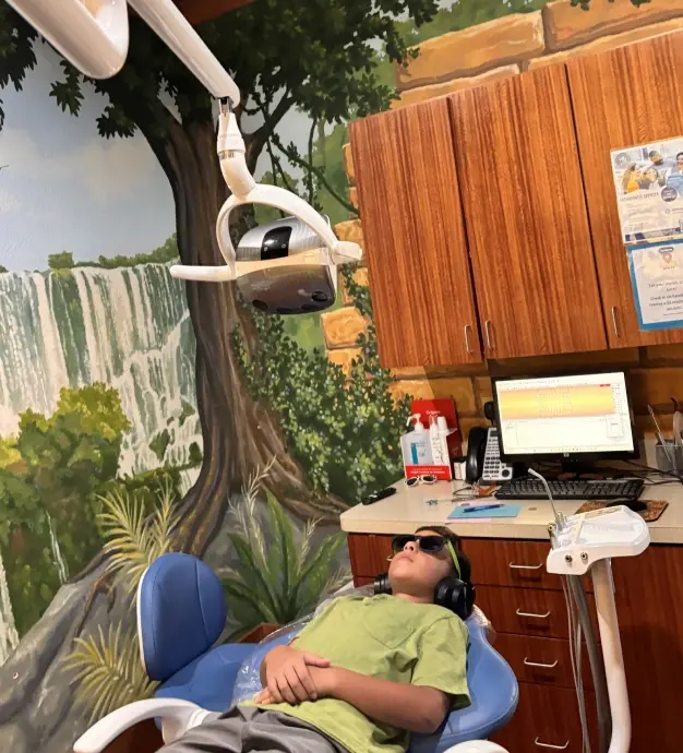 Young patient relaxing in dental chair during examination at McKinney dental practice.
