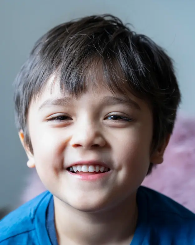 Young boy smiling brightly, displaying healthy teeth after restorative dental treatment in McKinney.