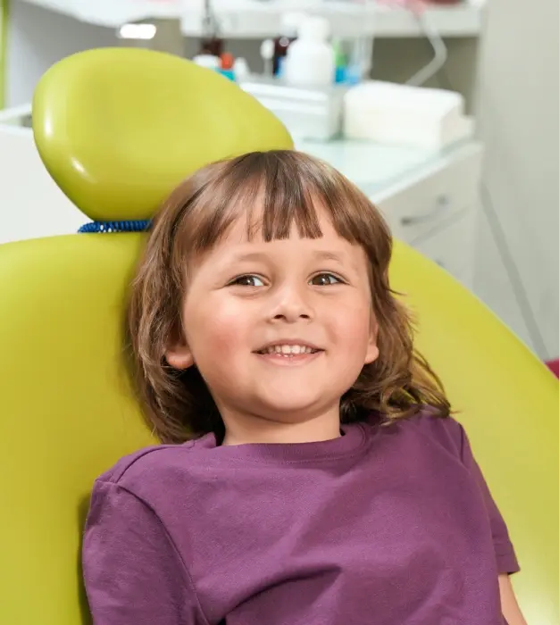 Young patient smiling in dental chair during sedation dentistry consultation.