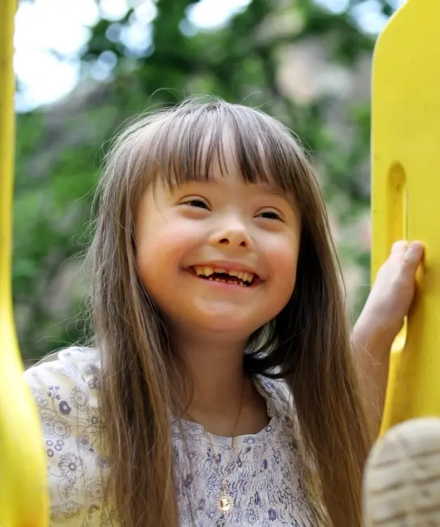 Happy child with Down syndrome smiling at dental practice in McKinney, TX.