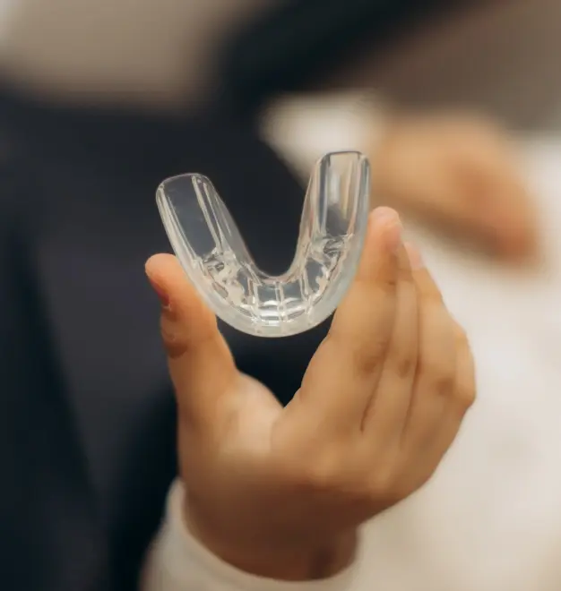 Clear sports mouthguard held in hand for dental protection.