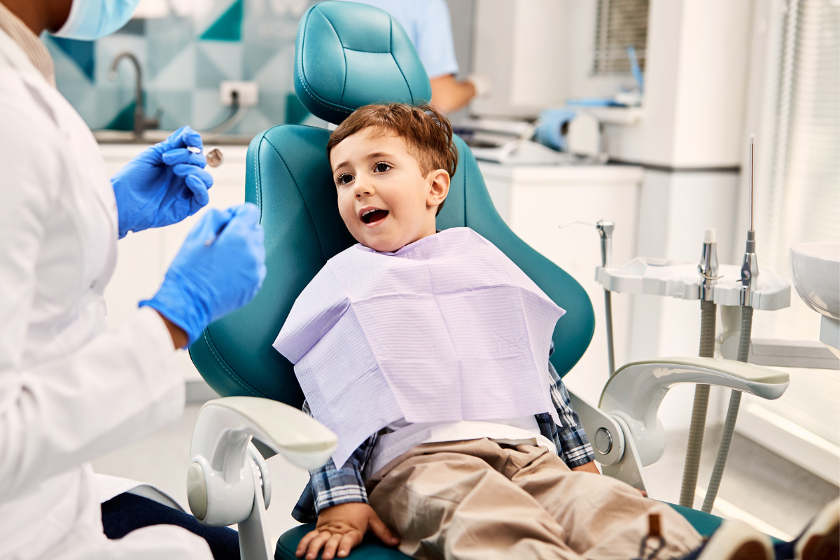 Young boy smiling in dental chair during checkup with pediatric dentist in McKinney.
