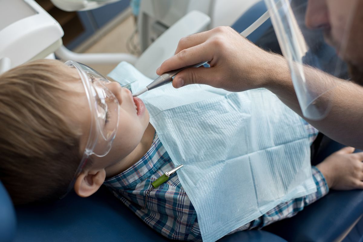 Pediatric dentist evaluating a child's mouth after a dental injury in McKinney TX