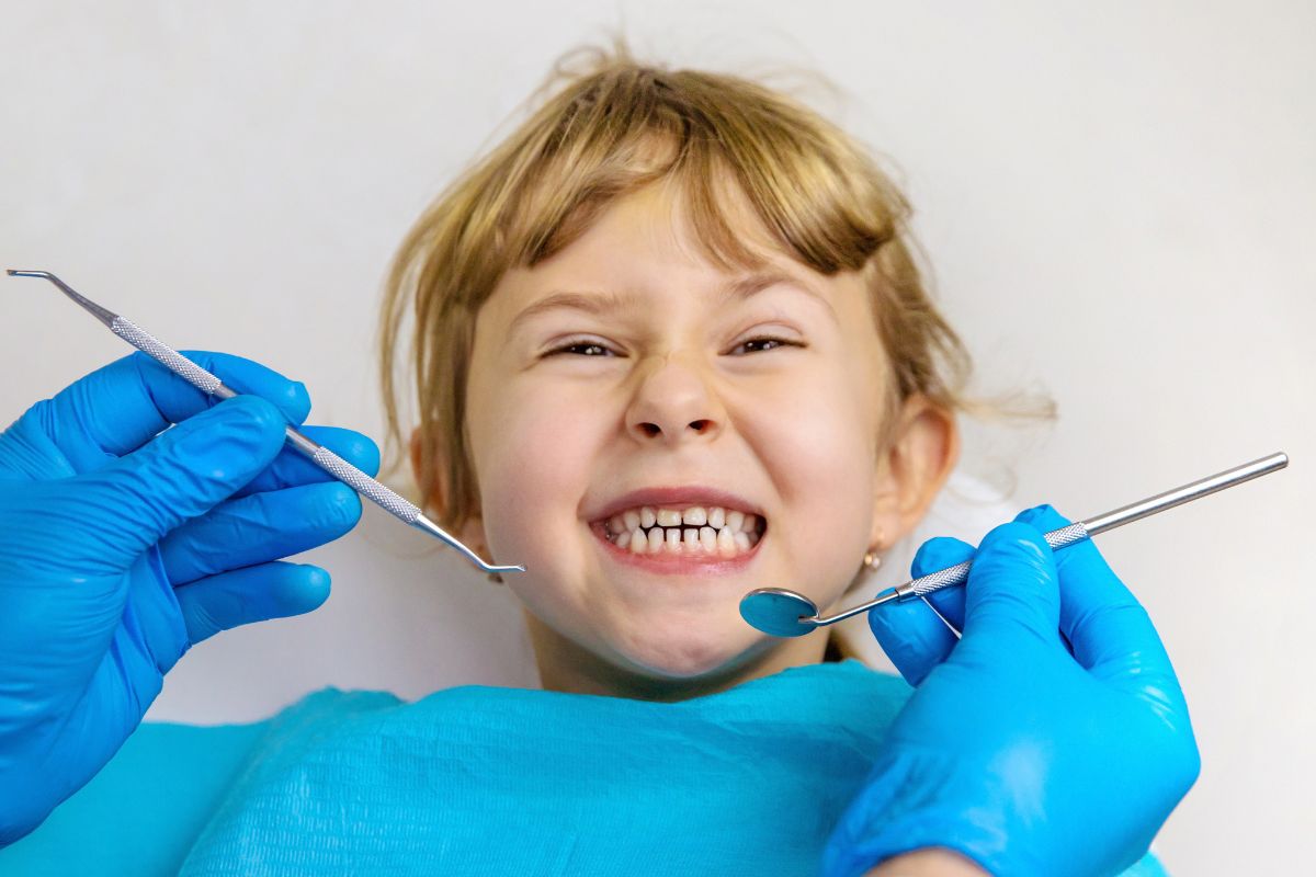 Pediatric dentist examining a child's teeth during a routine dental visit in McKinney TX