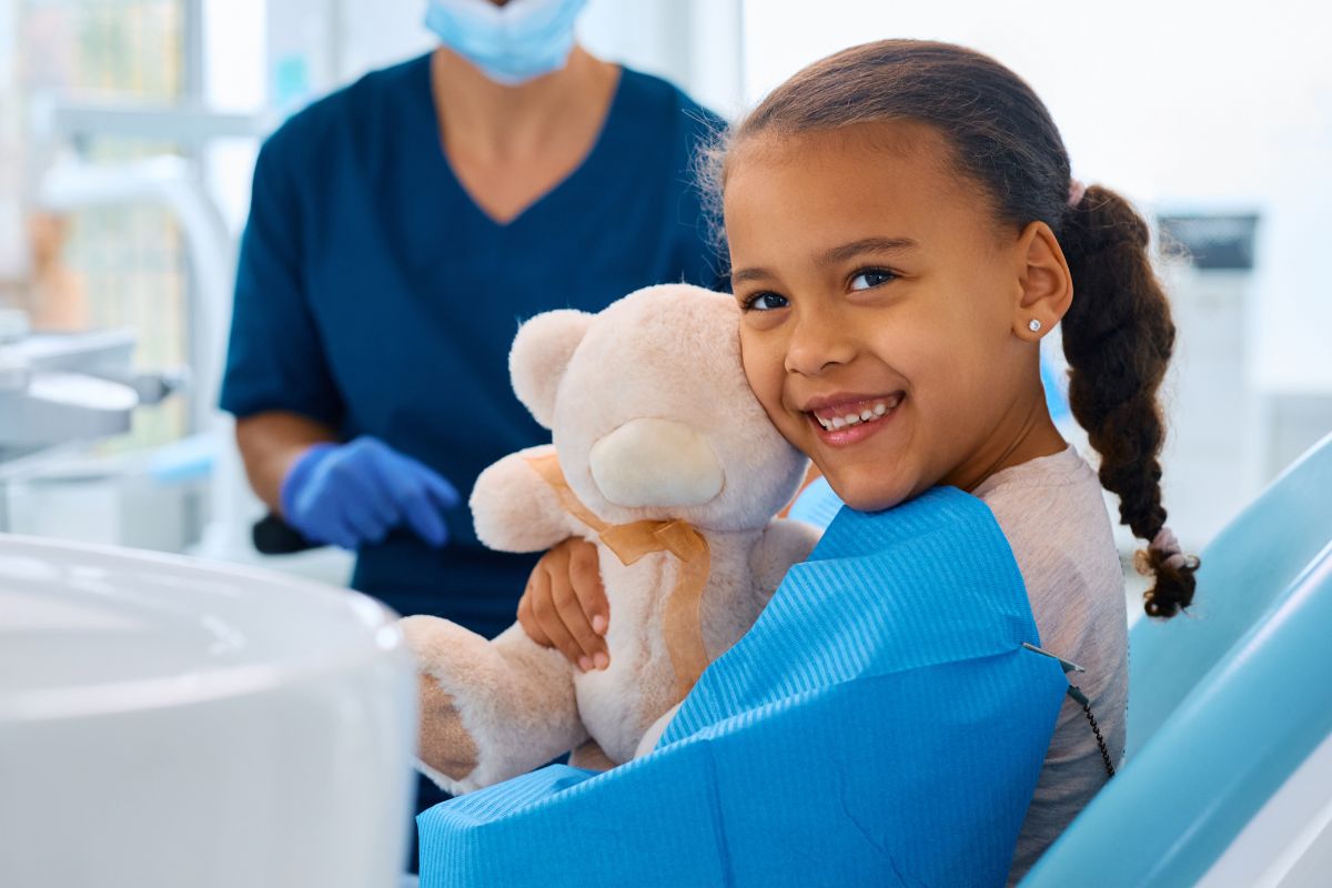 Pediatric dentist welcoming a young child for a first dental visit in McKinney TX
